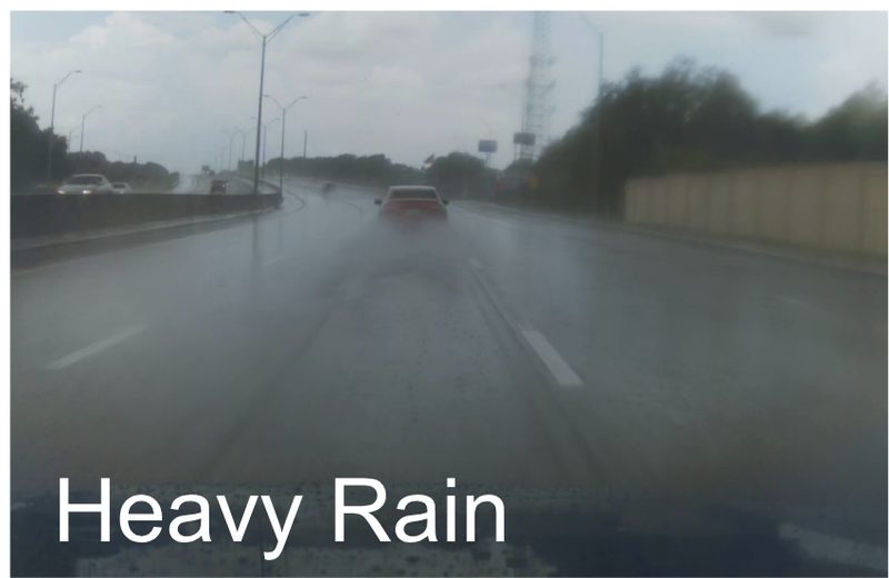 Interstate in heavy rain; spray from the vehicles ahead hides both lane lines