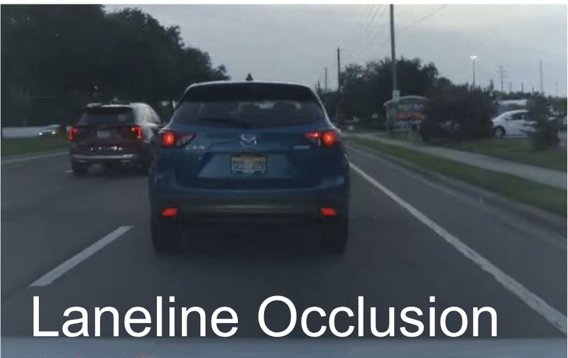 A blue SUV close ahead hides the lane line from the camera